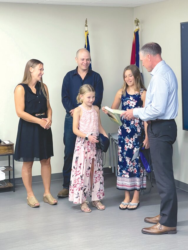 Mercy Perry Administrator Chris Wibbenmeyer (right) recognizes Kayda (center) and Kali Ernst during the hospital&rsquo;s July board meeting. Also pictured are the girls&rsquo; parents, Adam and Alissa Ernst.
