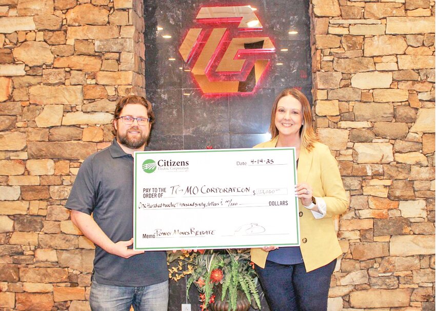 Dylan Carpenter, TG Missouri environmental project  engineer, and Emily Blyzes, Citizens Electric Corporation  billing and operations specialist, hold a faux  $112,060 check to celebrate the money received by the  company for its energy efficiencies.