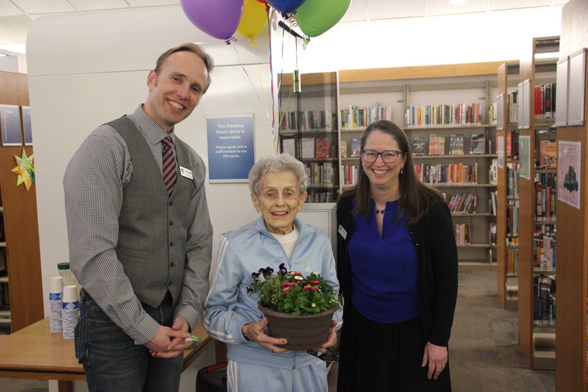 To celebrate National Library Week, Joyce Vanderpol was honored with a plaque and flowers in the Blaine library on April 9 by Whatcom County Library System executive director Christine Perkins and Blaine library manager Jonathan Jakobitz for her donation toward a private work space that was installed in the library last year. Vanderpol, who recently turned 100 and still runs her own real estate business, Vanderpol Realty & Notary, has been an active patron for many public services around the community for years.