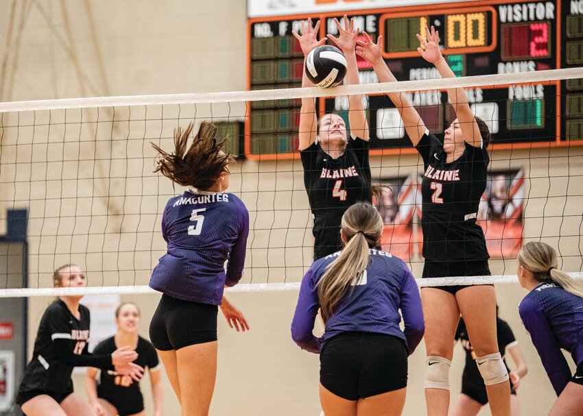 Junior outside hitter Carly Saunders, c., and sophomore outside hitter Teia Dube, r., block an Anacortes spike during the second set of Blaine’s 3-0 loss on October 15. Dube tallied four kills, five digs and one ace in the loss.