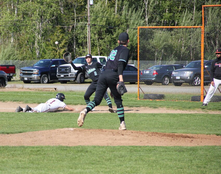 Aaron Garza, l., dives into first base after a single against Mt. Vernon on April 29.