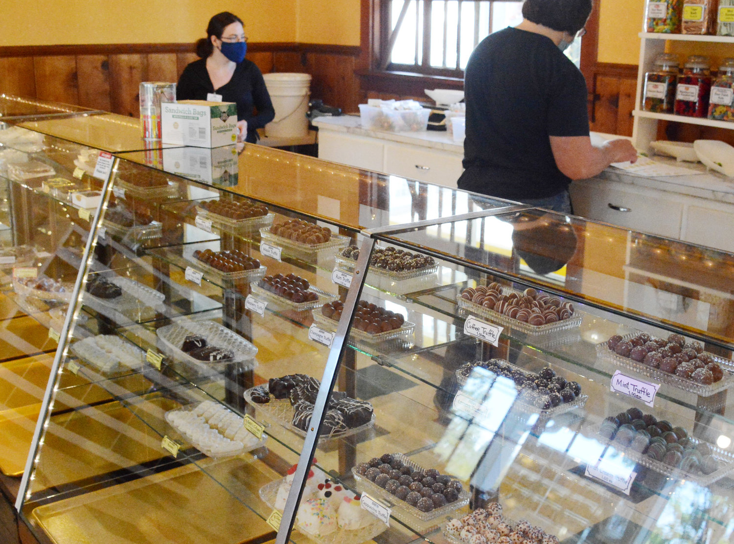 The chocolate case on reopening day. The C Shop originals have yellow labels, while those made by other chocolatiers have a white label.