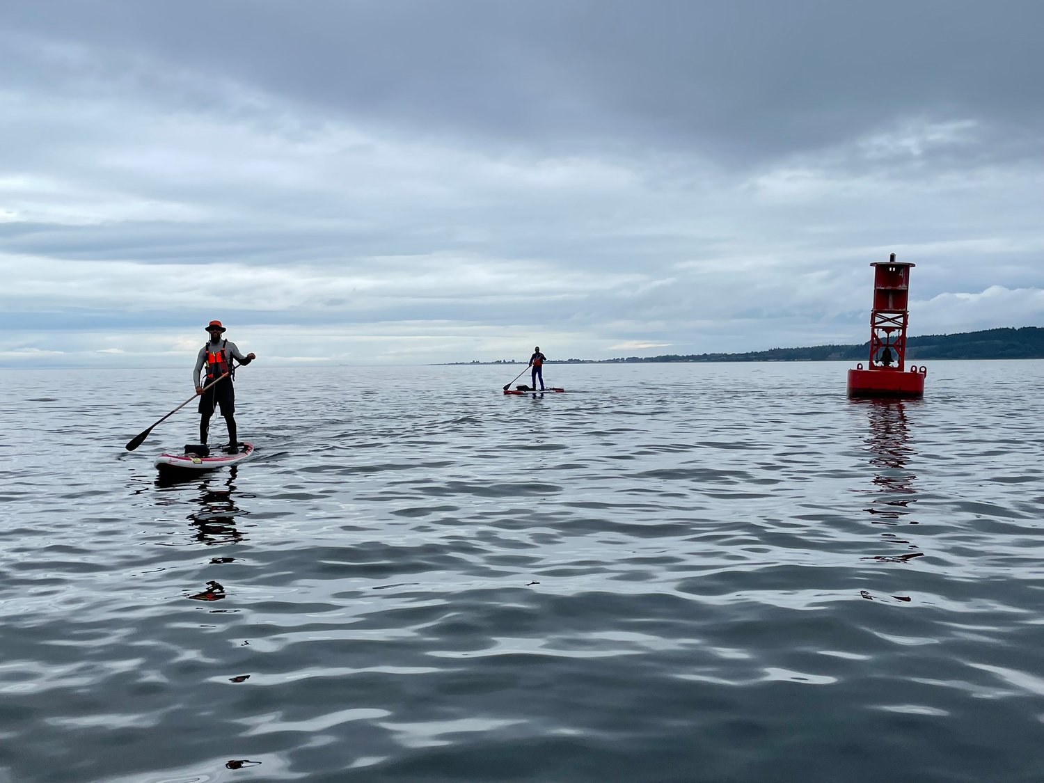 Two stand up paddleboarders round the Point Roberts buoy on the last leg back to Port Townsend and the finish of the WA360 race.