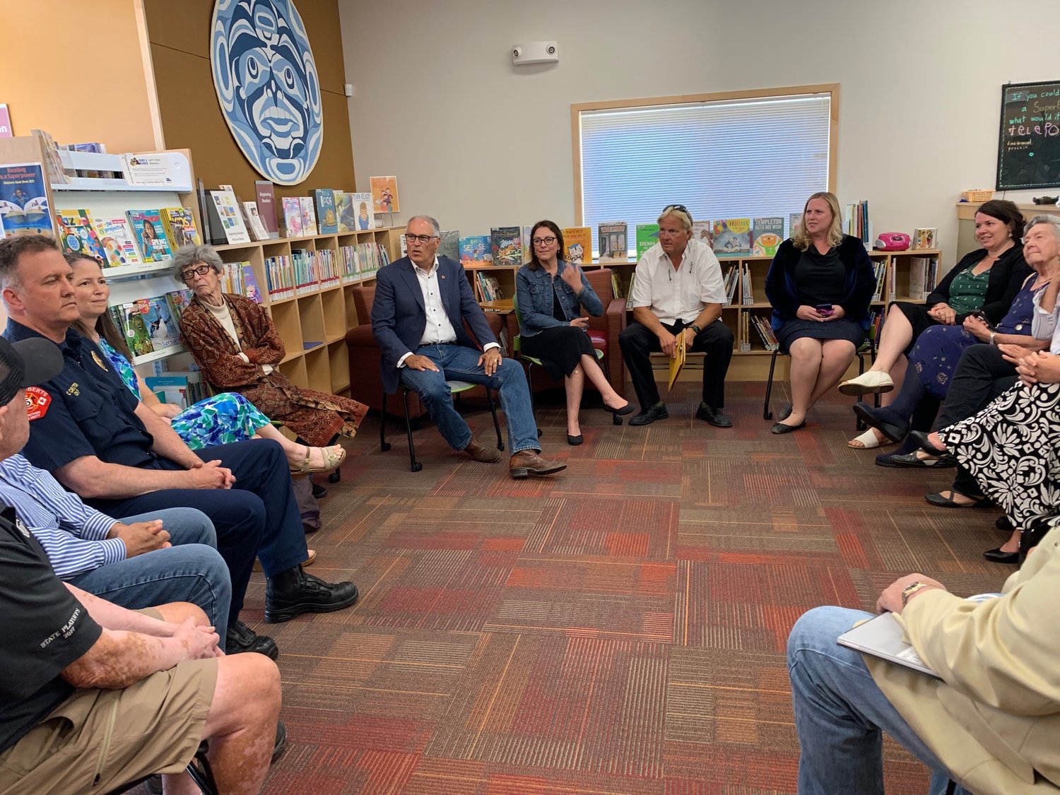 Governor Jay Inslee, congresswoman Suzan DelBene and state representatives Alicia Rule and Sharon Shewmake meet with a group at the library.