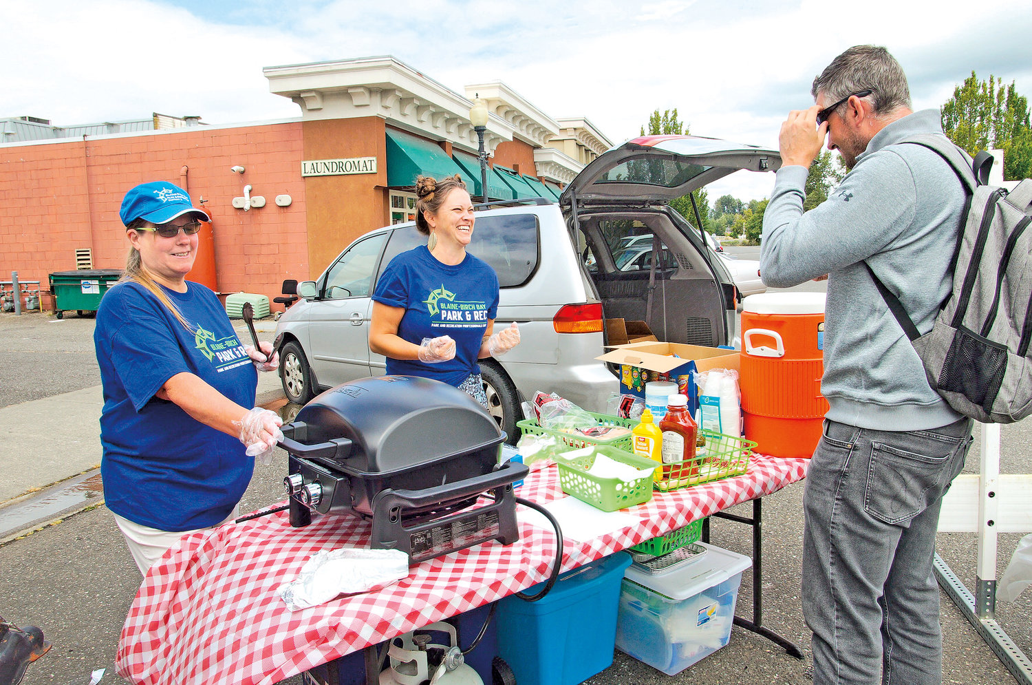 Blaine-Birch Bay Park and Recreation District 2’s Heidi Holmes and Kaileigh Hubbard serve hot dogs and chips to Splash Days attendees.