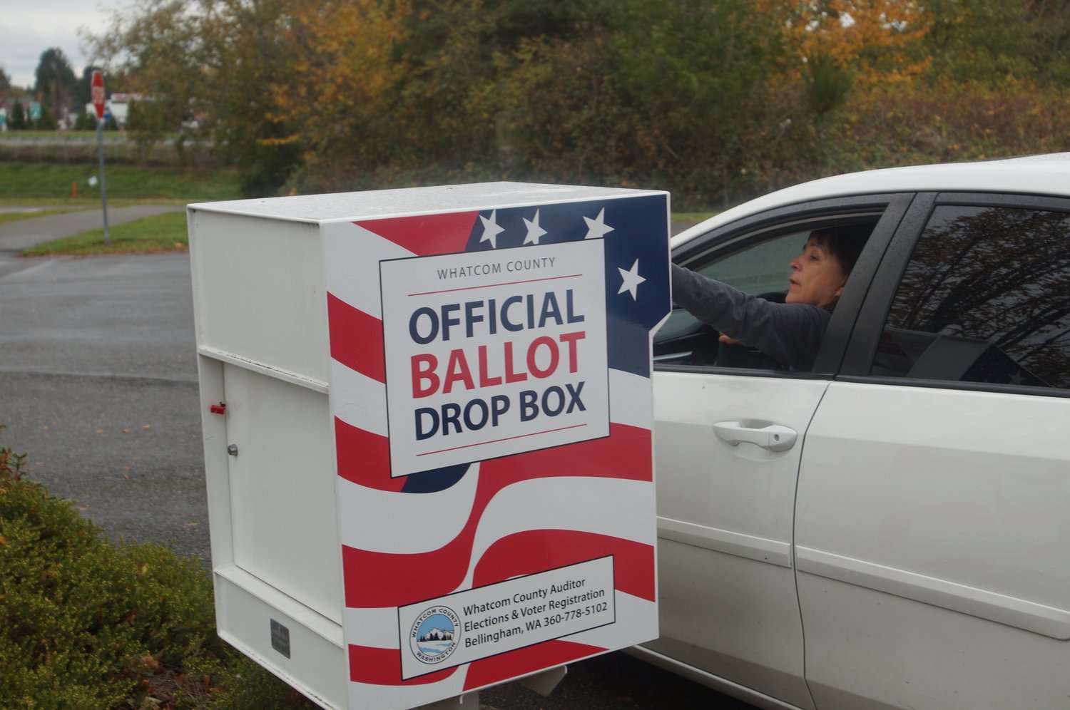 A Whatcom County voter places her ballot in the Blaine Library drop box on Election Day 2021.
