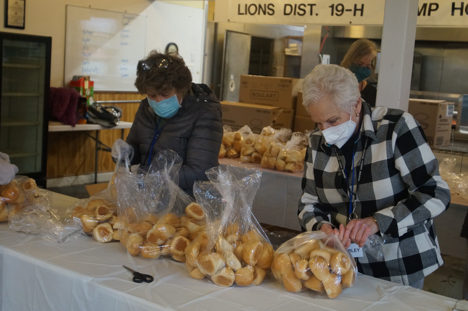 Community Assistance Program (CAP) volunteers finish up the last things they need to do before distributing the family Thanksgiving meal baskets on November 23, 2021. Baskets include turkey, cranberry sauce and rolls among other tasty ingredients.