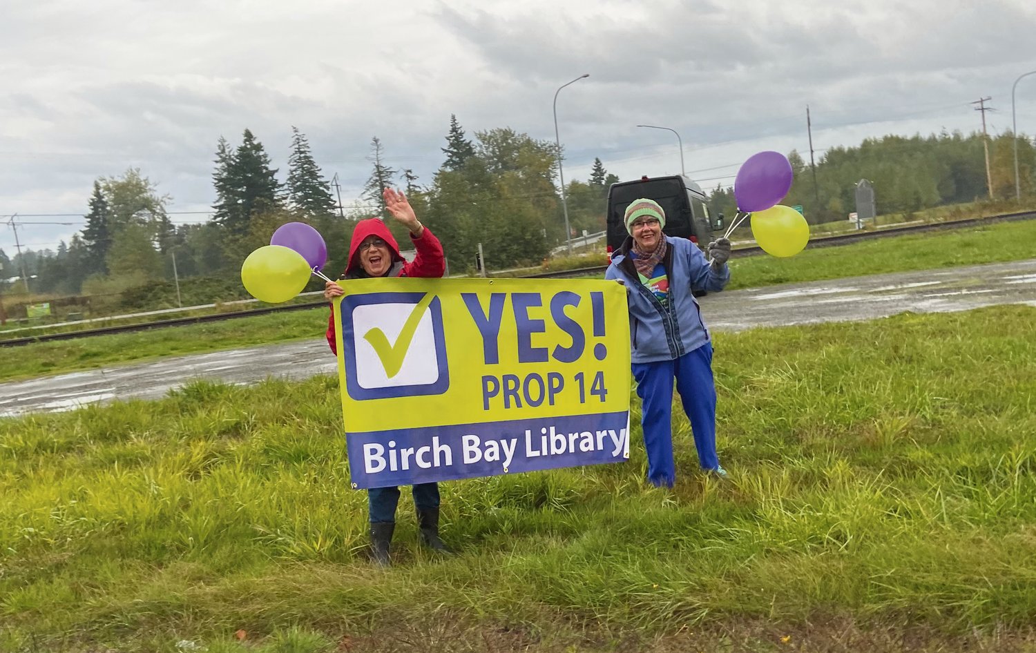 Friends of the Birch Bay Library members wave signs in support of Proposition 14 before the November 2021 election.