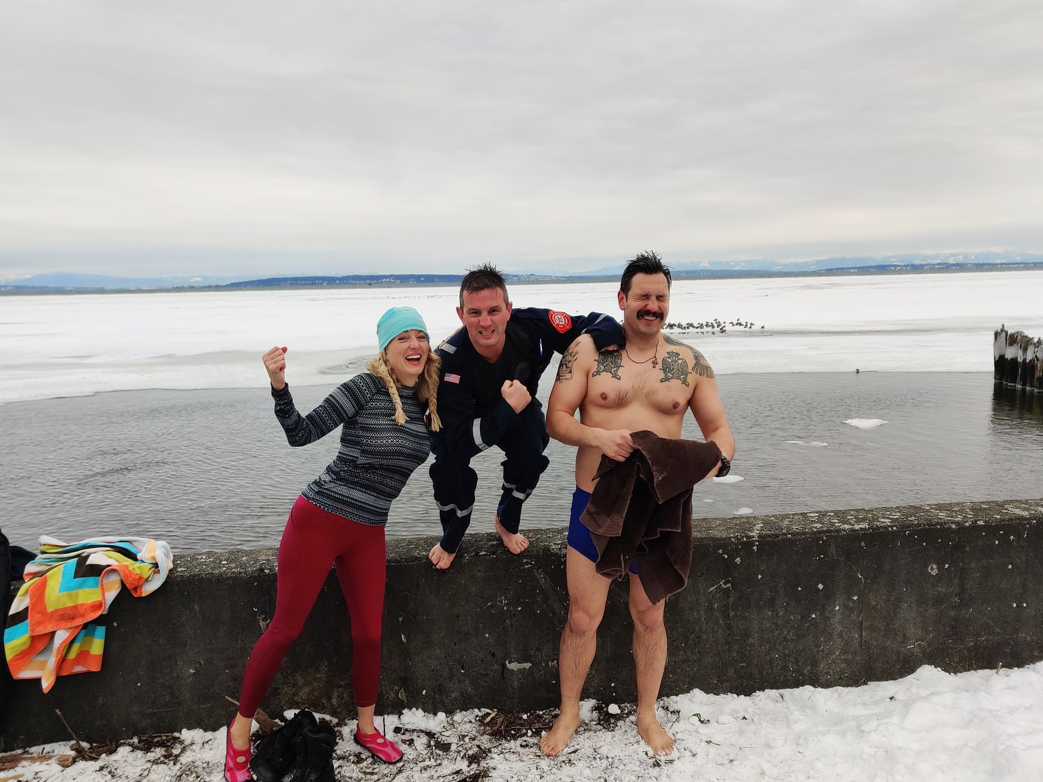 Only three swimmers braved the ultra-cold waters in the Annual Maple Beach Polar Bear Swim on January 1, 2022. Seen shivering are, from l., Savila Kress, Point Roberts fire district members Christian Craig, firefighter/AEMT and Boris Boskic, firefighter.