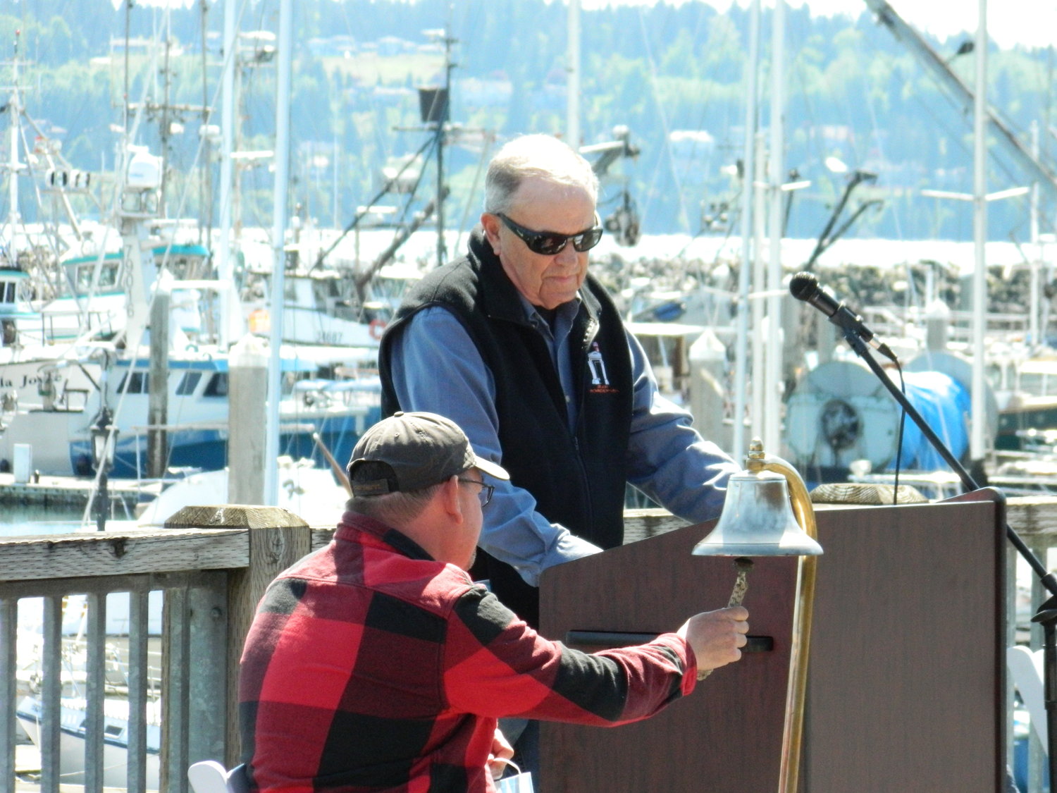Gary Dunster watches as Jason Burk rings the bell during the 2021 Blessing of the Fleet at Blaine Harbor.