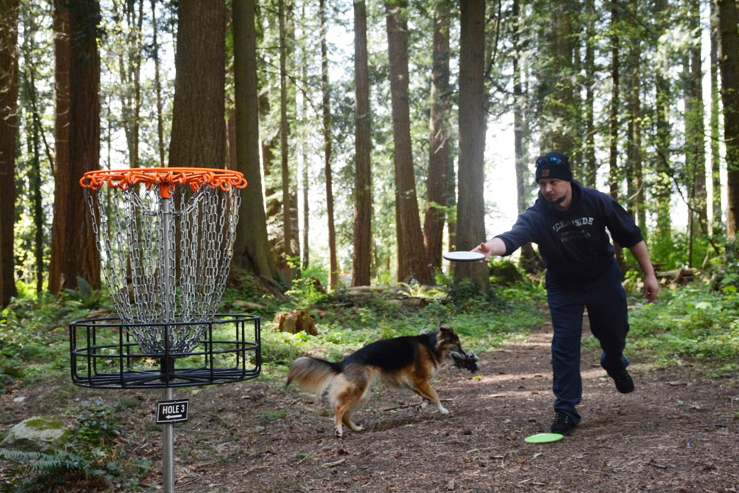 Mike Williams makes a shot on hole three of Lincoln Park’s disc golf course April 29. He said he plays about four times a week with his dog, Frankie.