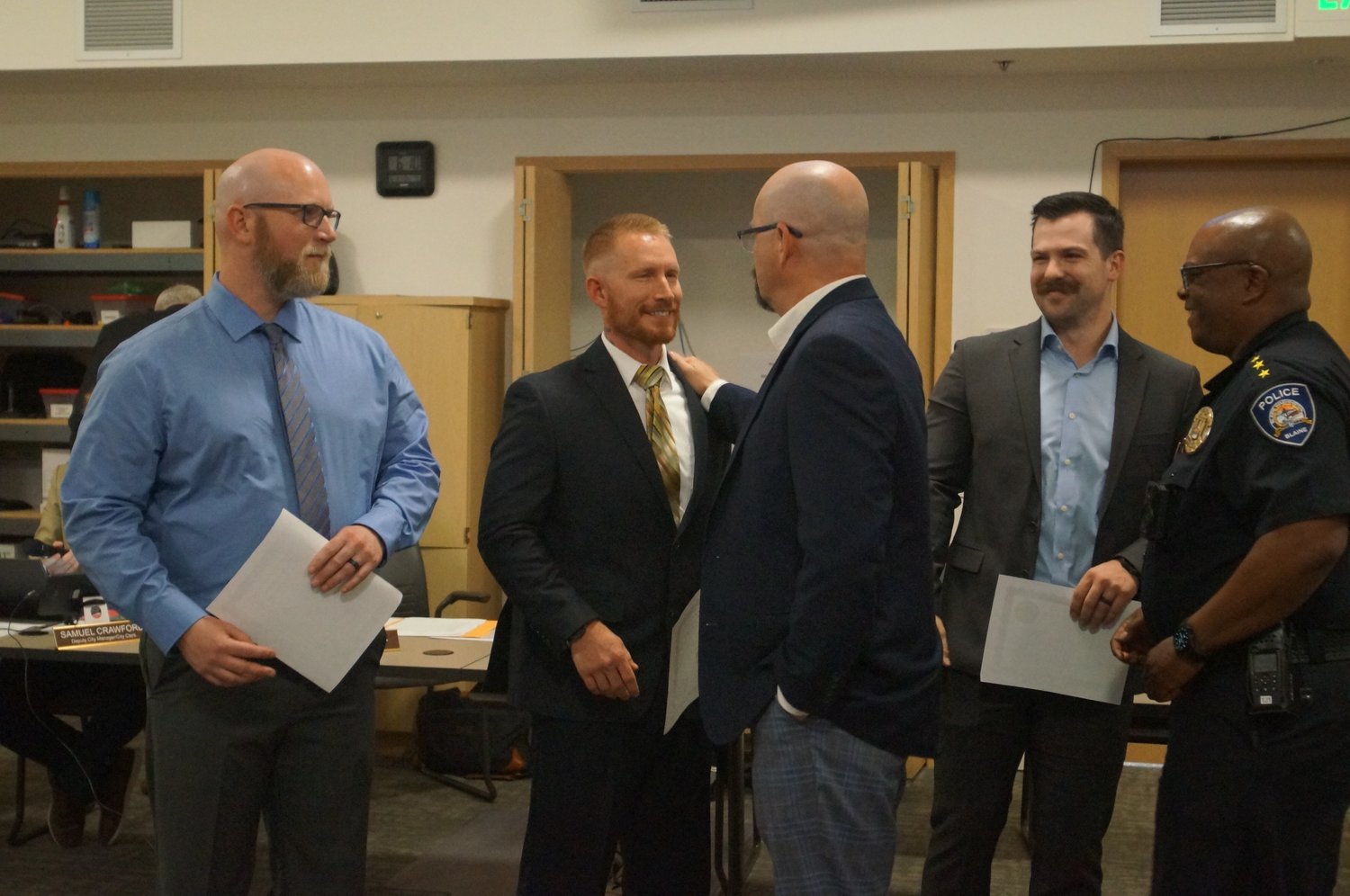 Blaine city manager Michael Jones and police chief Donnell Tanksley congratulate the new Blaine Police Department officers from l. Kevin O’Neill, Jeremiah Leland and Benjamin Diacogiannis who were sworn in during the June 13 Blaine City Council meeting.