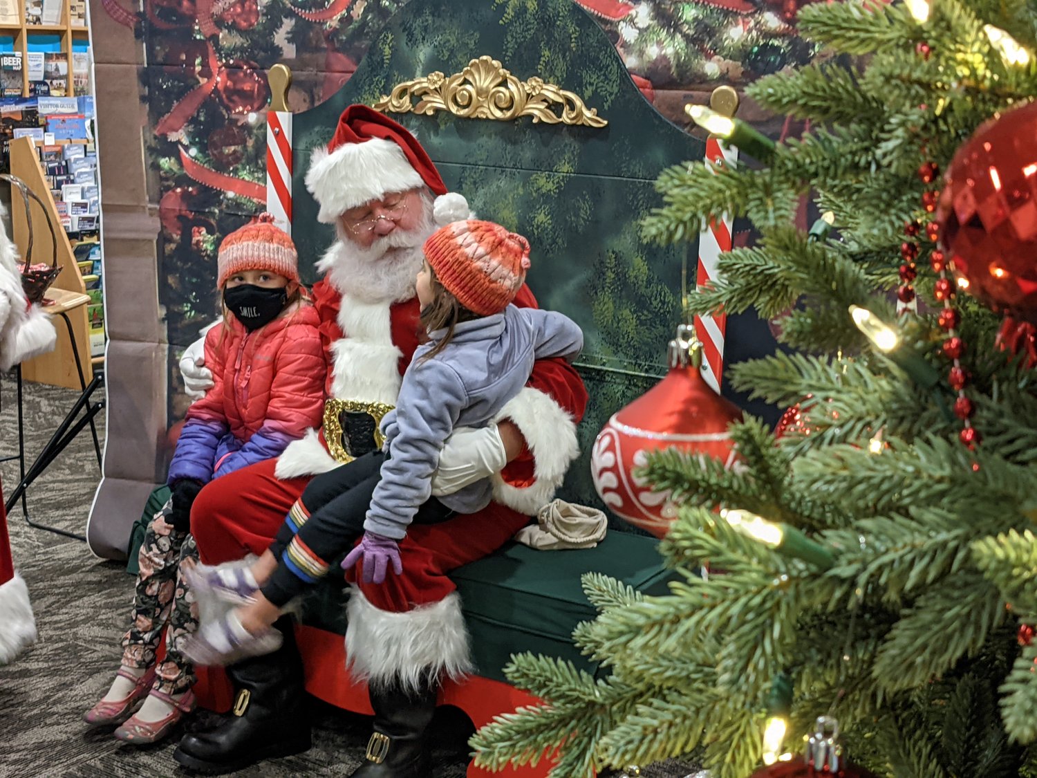 Children sit with Santa Claus during the 2021 Holiday Harbor Lights festival.