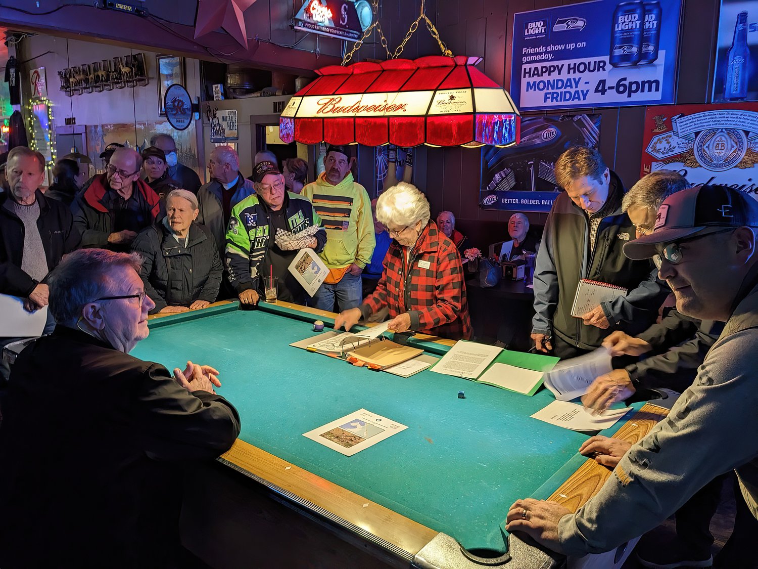 Whatcom County councilmember Ben Elenbaas (r.), Birch Bay residents and Whatcom County Public Works Department staff huddle around a pool table at Tony’s Tavern to discuss the new Birch Bay stop sign ordinance on March 2.