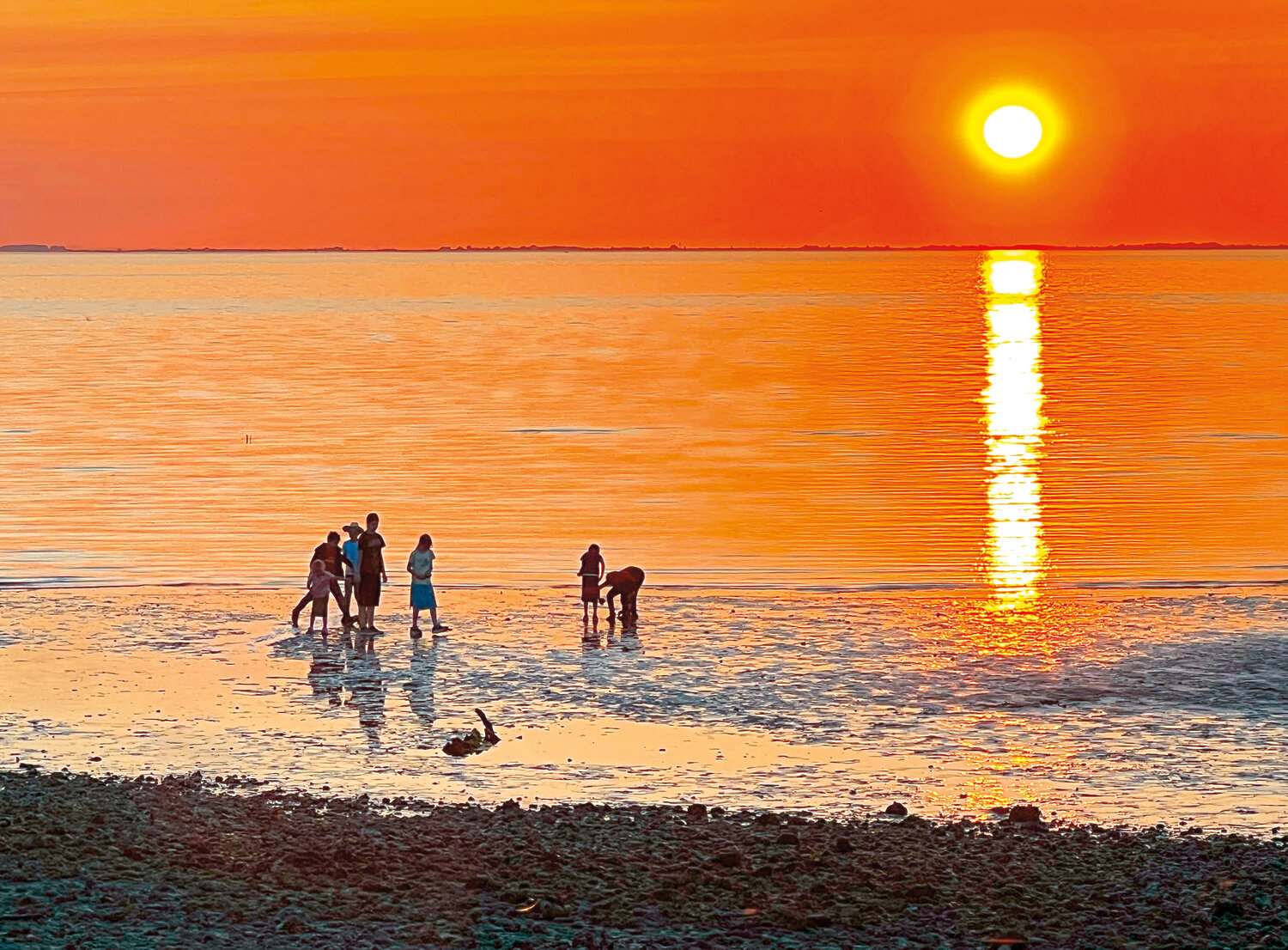 A fiery orange sunset brightened the sky over Semiahmoo Bay on the evening of May 15. Beach-goers at Semiahmoo Park found relief from unusually high temperatures during a heat advisory that the National Weather Service issued for areas of western Washington from May 13 through May 15.