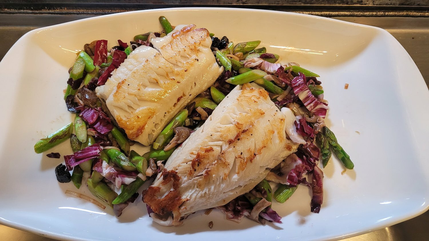 Pan-seared black cod with spring asparagus sauté.