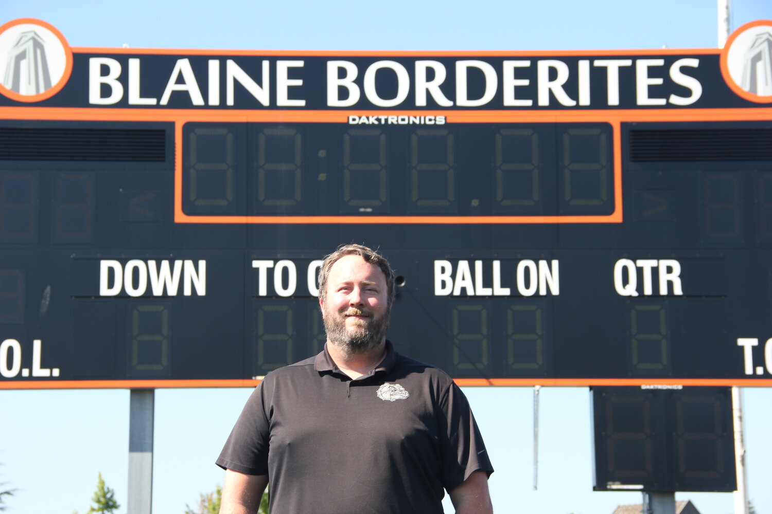 Andy Olson stands in front of Blaine Stadium’s scoreboard during preseason practice. Olson was raised on Whatcom County football, and hopes to grow and bring sustained success to the Borderite program.