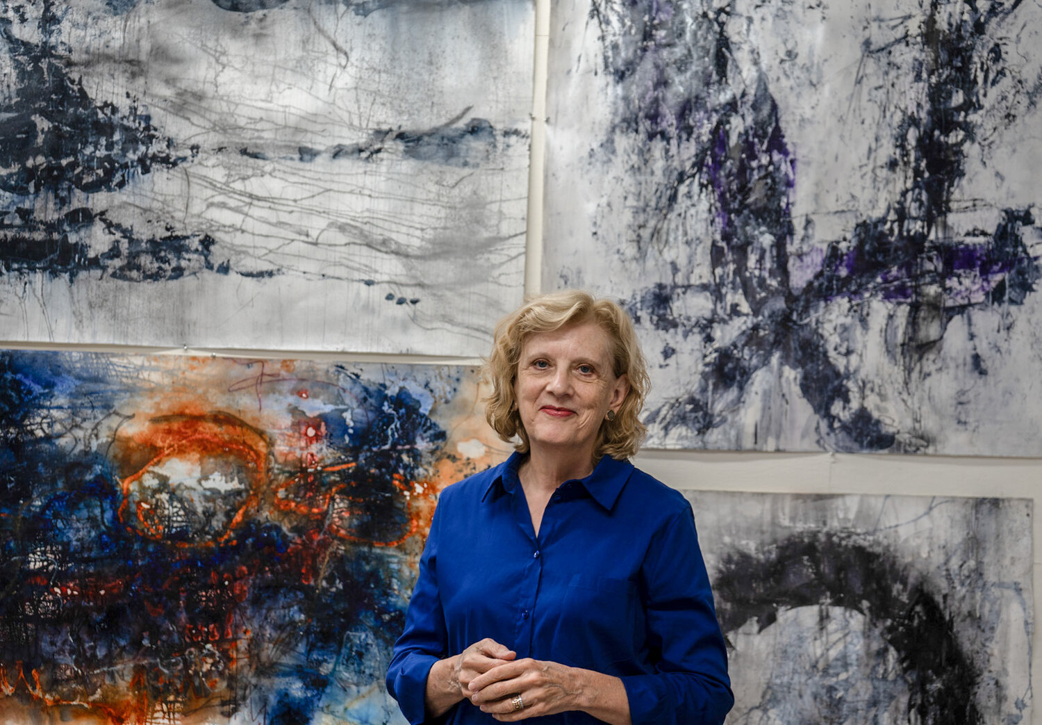 Vaune Ainsworth stands in front of her recent, unreleased abstract work. Her art is free-flowing and never preplanned.