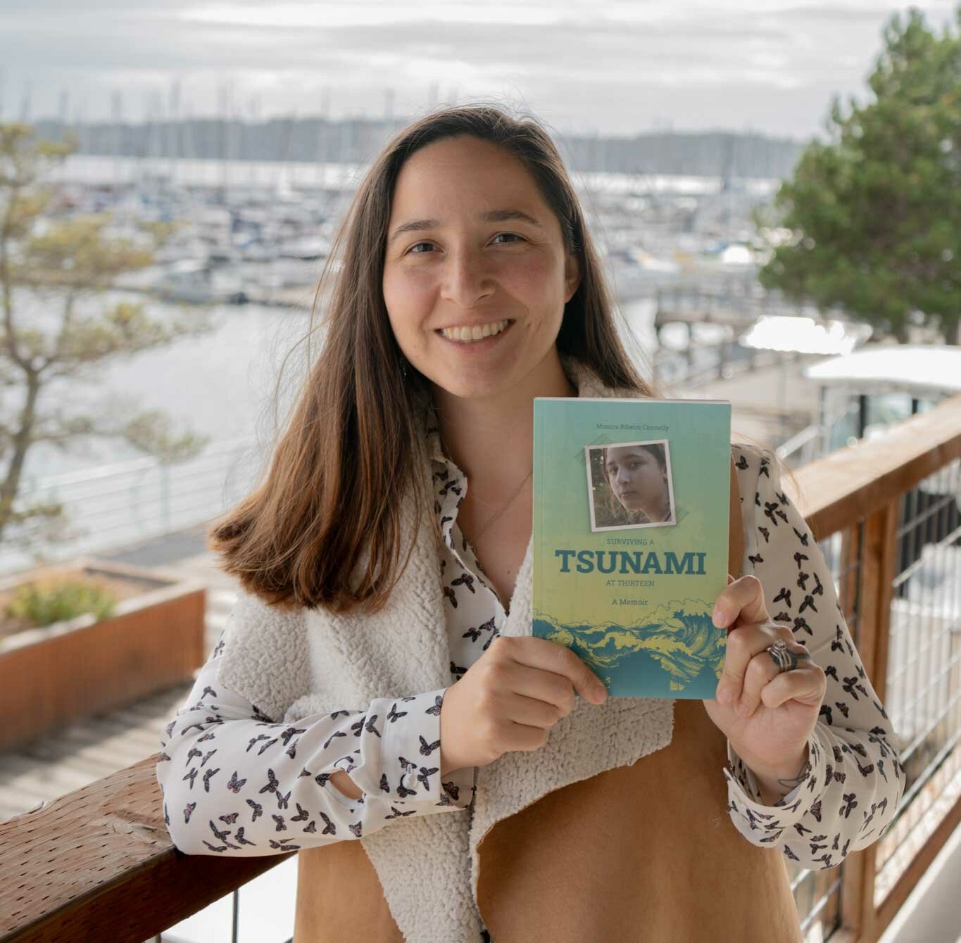 Monica Ribeiro Connelly holds a copy of her recently released memoir “Surviving a Tsunami at Thirteen.”