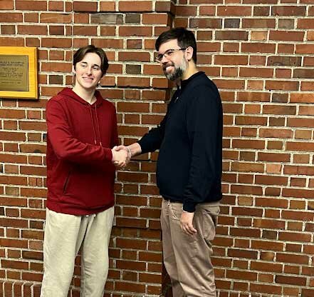Blaine High School junior Carson Roesch, l., is congratulated by Washington Chess Federation president Josh Sinana after winning the state tournament on January 20.