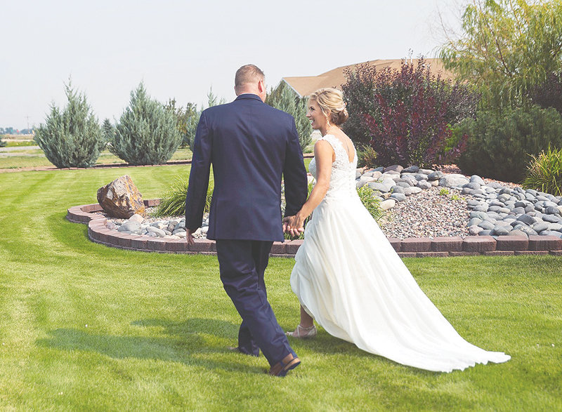 Clay and Lisa Lynn walk together during their August wedding at Joy Bessler&rsquo;s property west of Powell. Bessler can cater weddings across the area, but also offers her own home as a venue.