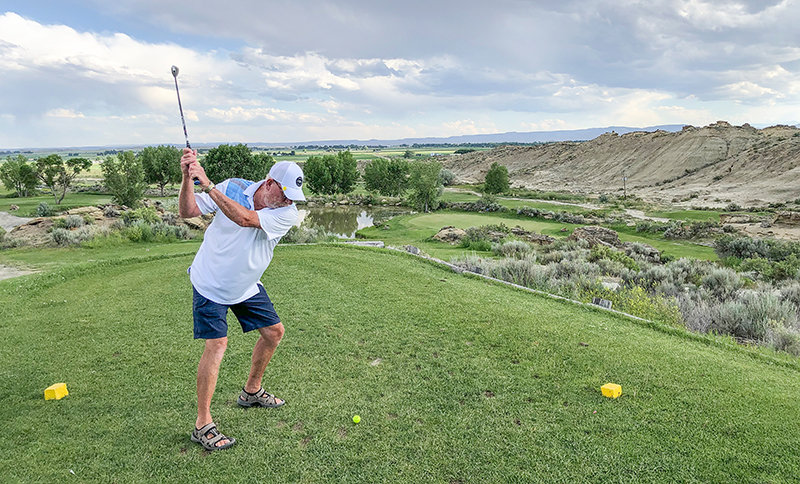 Powell Golf Club pass holder Marc Saylor of Powell tees off on the club&rsquo;s signature hole, the par 3 fourth. Saylor carded more than 150 rounds at Powell Golf Club in 2021.