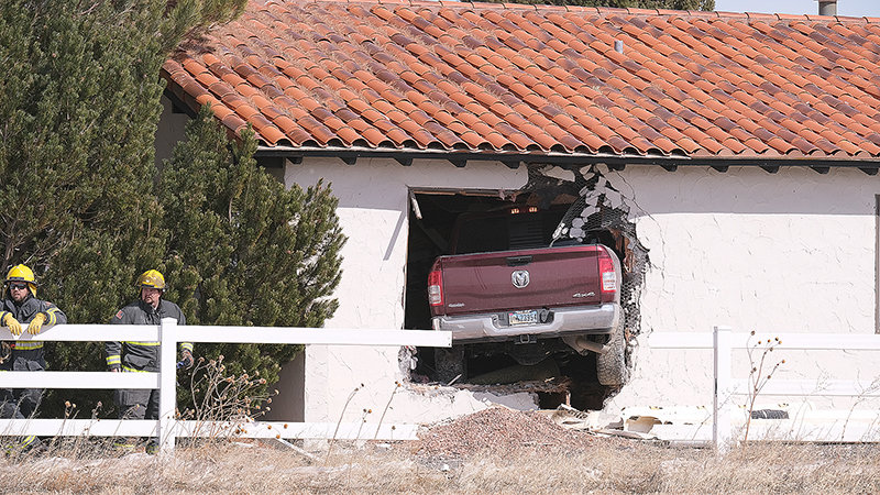 Willie Onstine, left, and Kacey Spomer respond to a crash into a home on Lane 11 1/2 on April 13. The driver hit a concrete irrigation ditch causing the vehicle to become airborne and crash into the home.
