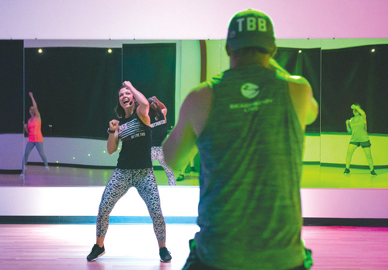 Melanie Matthews leads a combat fitness class at Club Dauntless while her husband, Jeff, joins in on the workout. The Matthews family, including their three children, have embarked on a lifestyle of fitness, in part to help recover from severe injuries.