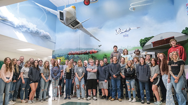 Powell High School students stand proudly in front of the F-22 Raptor and its accompanying display, which they helped create.