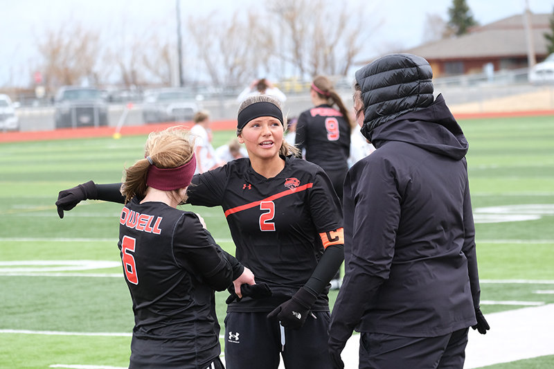 Kaitlin Loeffen (right) helps discuss strategy with Kabrie Cannon (left) and Jordyn Dearcorn (middle) during a blustery contest against Cody in April.