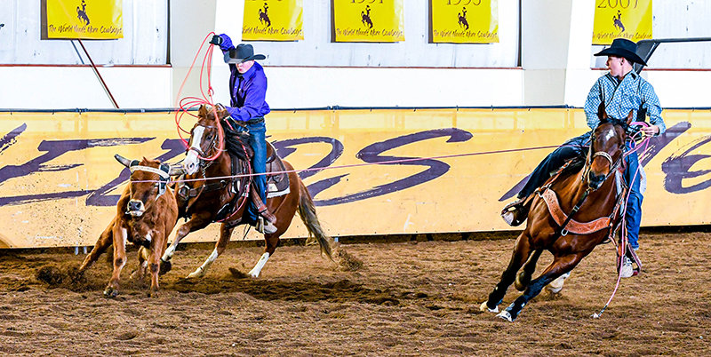 Casen Gines (right) turns the steer after a successful head catch as he waits for his partner Ryder Moorman (left) to finish the run as the heeler during a competition in Laramie. Gines heads to Perry, Georgia, to compete in the team roping starting this Sunday.