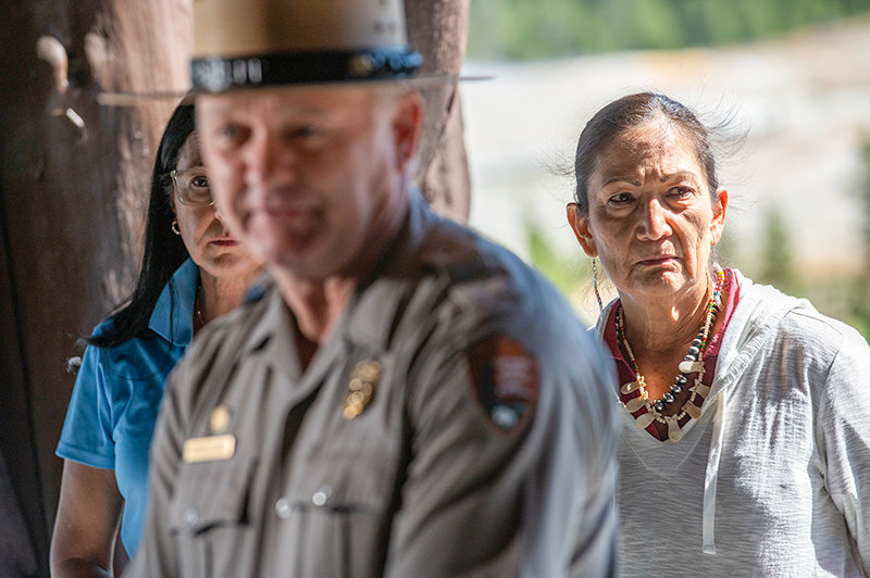 U.S. Secretary of the Interior Deb Haaland, right, listens as Yellowstone National Park Superintendent Cam Sholly gives an update Friday at the Old Faithful Inn on efforts to repair road and infrastructure damage in the northern part of the park caused by severe flooding last month.