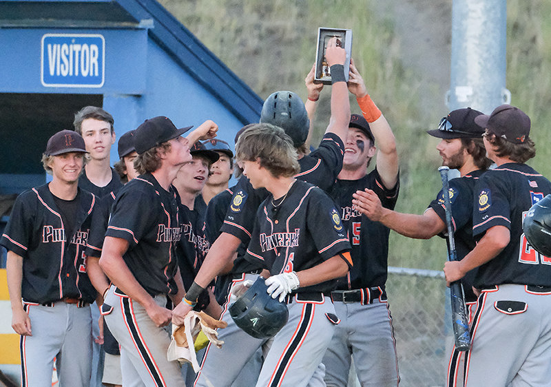 The Powell Pioneers gather around to celebrate Trey Stenerson&rsquo;s home run that sparked a late push, helping the Pioneers win their final regular season games heading to the West District A Tournament starting Monday.