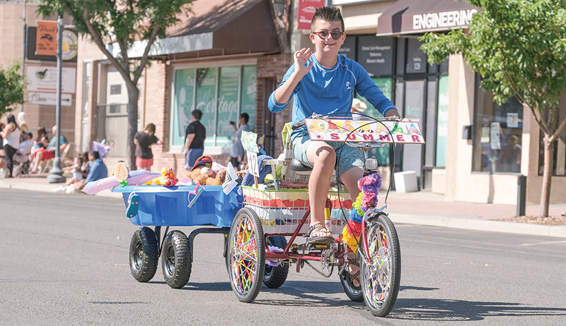 Noah MacDonald rides in his third parade in Powell. This year&rsquo;s float was a pool party populated by MacDonald&rsquo;s stuffed animals.