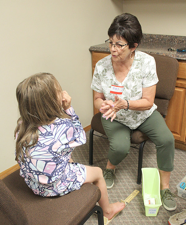 Rock Springs volunteer Pat Sisneros assists a Sweetwater County student in need of a pair of new shoes for school.