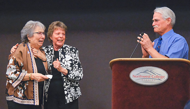 Northwest College Board chair Dr. Mark Wurzel (right) announces the renaming of the Intercultural House for Harriett Bloom-Wilson (left) on Thursday during Taste the Nations as trustee Carolyn Danko holds the longtime teacher and college volunteer.
