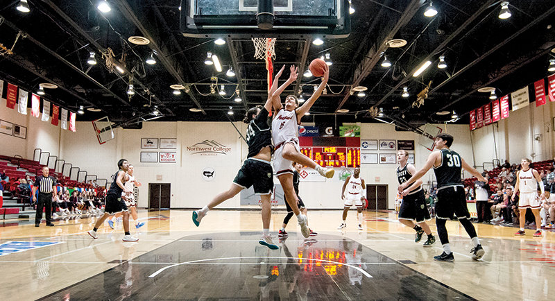 NWC Trapper Juan Pablo Camargo Tellez finishes hard at the rim against a Rocky Mountain JV defender during the second half on Friday.