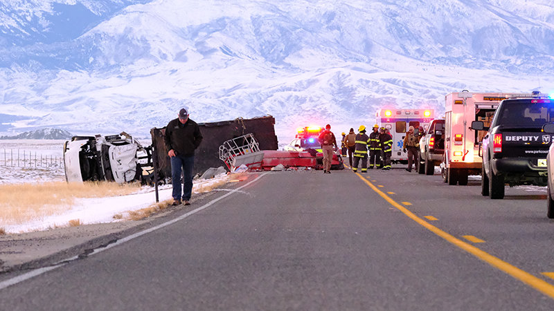 Clark Fire Chief Nate Hoffert walks away from the scene of a Friday afternoon crash, in which a commercial truck rolled after reportedly swerving to miss another vehicle. The Wyoming Highway Patrol is seeking information about the crash.