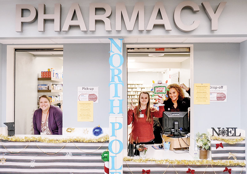 Powell Valley Healthcare pharmacy employees Kendra Glass, Taylor Libby and Nicolle Cruz show off the traveling trophy awarded to departments that win the annual holiday season decorating contest. The pharmacy won for the first time this year.