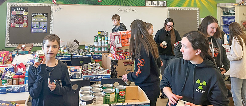 Students and teachers pitch in to sort and organize over 1,400 pounds of food following a food drive organized by the Powell High School student council and National Honor Society. Pictured are Joshua Varian (left) and PHS junior Kik Hayano.