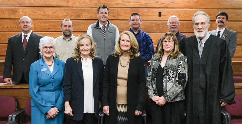 District Court Judge Bill Simpson, first row at right, swore in the county elected officials, both new and incumbent, who started new terms in January, including: First row, from left, county clerk Colleen Renner, treasurer Barb Poley, commissioner Dossie Overfield, Clerk of District Court Debra Carroll; second row, attorney Bryan Skoric, commissioner Lloyd Thiel, coroner Cody Gortmaker, commissioner Scott Steward, assessor Pat Meyer and sheriff Darrell Steward.