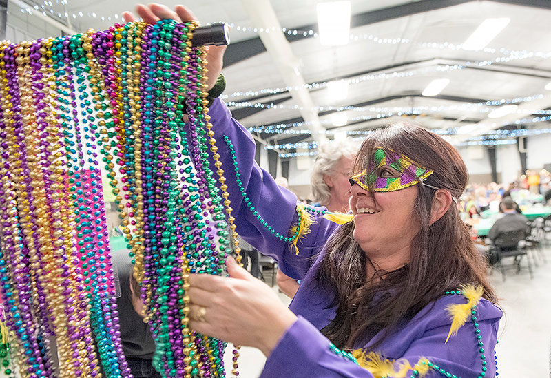 Simone Brien hangs up beads after the Mardi Gras celebration in Powell in 2019. Brien is a former respiratory therapist at Powell Valley Healthcare.