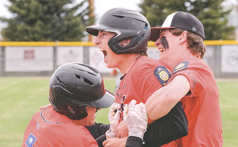 Cade Queen (middle) is swarmed by Aidan Wantulok (left) and Jhett Schwahn after he hit a walk off single for the Pioneers on Saturday.