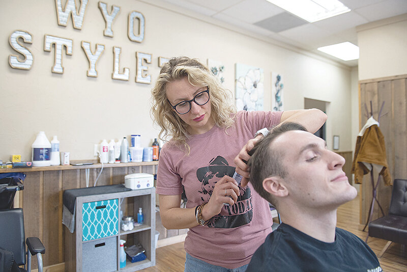 Galina Matsiakh, owner of WYO Stylez salon in Cody, cuts the hair of Kilian Trulik, a visitor to Cody. Matsiakh worked as a hair stylist in Kyiv when the war began, first fleeing to a border town when the Ukrainian capital began being shelled and then into Poland with her daughter when their temporary housing was damaged.