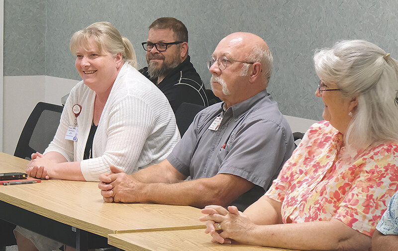 Joy Coulston (left) smiles after hearing the vote of a majority of board members to name her the next CEO of Powell Valley Healthcare at a June 7 special meeting of the Powell Valley Healthcare Board of Directors.