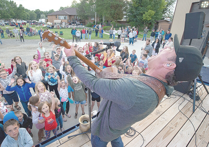 Harry Luge performs for children attending David and Jennie Rael&rsquo;s Fourth of July Celebration in Cowley on Tuesday. Hundreds enjoyed the party before being joined by even more people traveling to see the fireworks show.