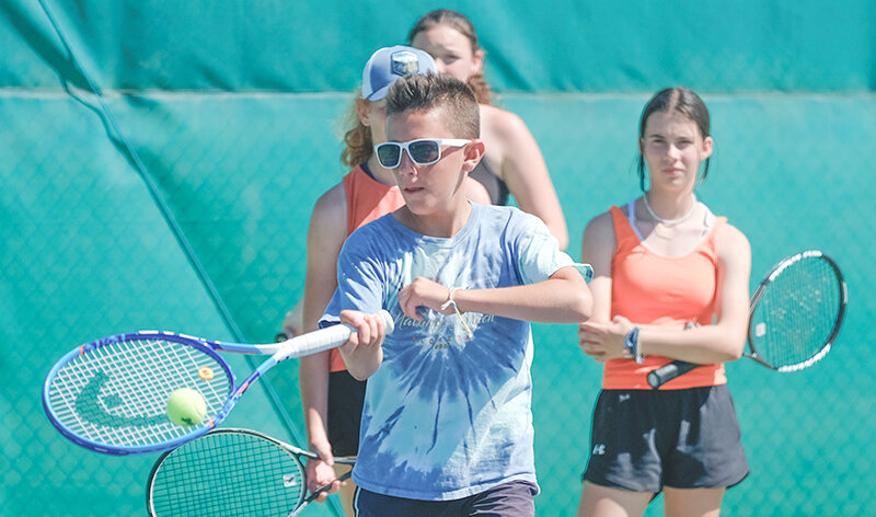 Cole McLeod moves up to hit a ball during drills at Powell High School last Thursday. The PHS tennis camp brought in athletes from Powell and Cody to compete in the weeklong camp.