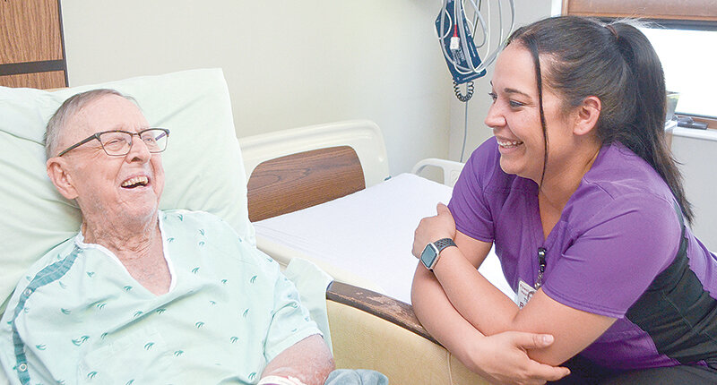 Powell Valley Healthcare nurse Tilly Hoffman speaks with patient James Davis.