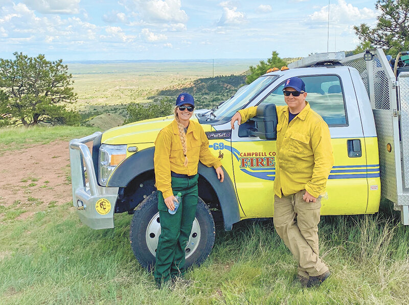Ellie Thomas (left) and her dad Terry pose for a picture in front of a truck while out in the field in Campbell County this summer.
