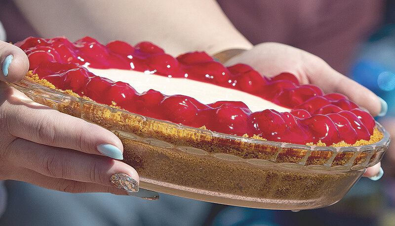 A cherry cheesecake made by Powell&rsquo;s Sheri Gifford goes up for auction during the 2022 Homesteader Museum pie auction. The top pie sold for $360 last year.